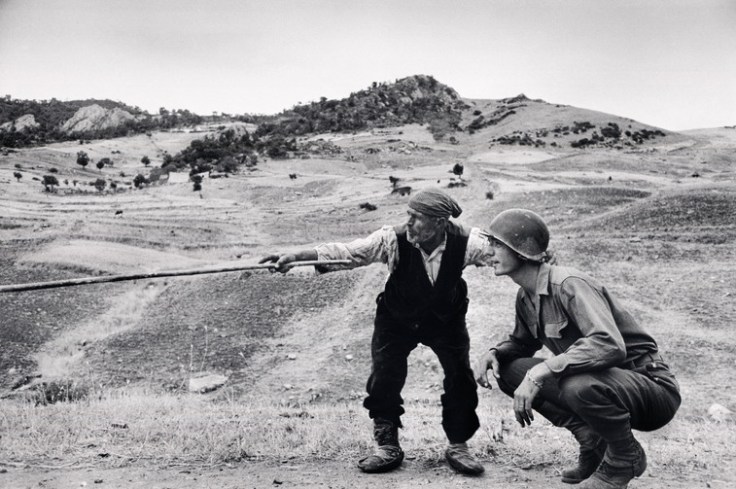 Contadino siciliano indica a un ufficiale americano la direzione presa dai tedeschi, nei pressi di Troina, Sicilia, 4-5 agosto 1943 © Robert Capa © International Center of Photography / Magnum Photos